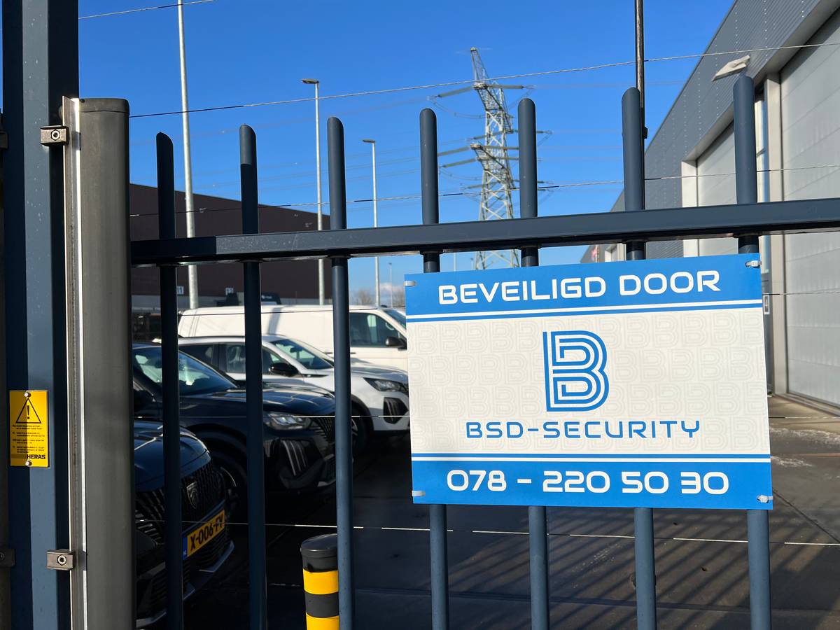 Bord Beveiligd door BSD-Security op een hek bij een parkeerplaats