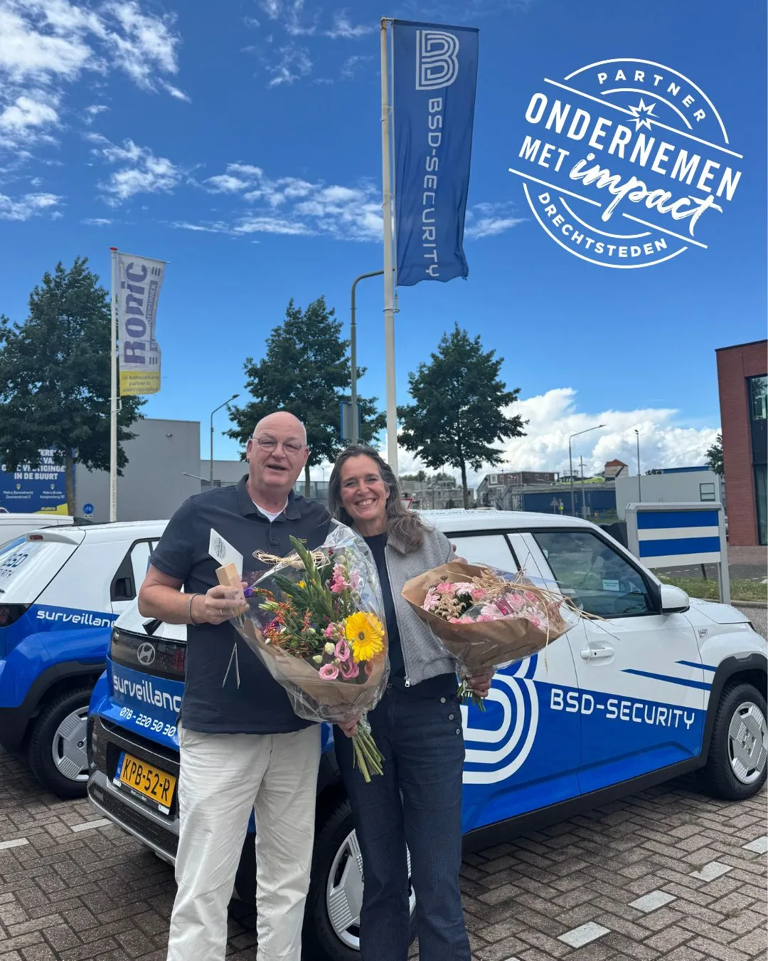 Henk Boxma van BSD Security ontvangt bloemen en het label Ondernemen met Impact voor het nieuwe pand aan de Jade in Dordrecht